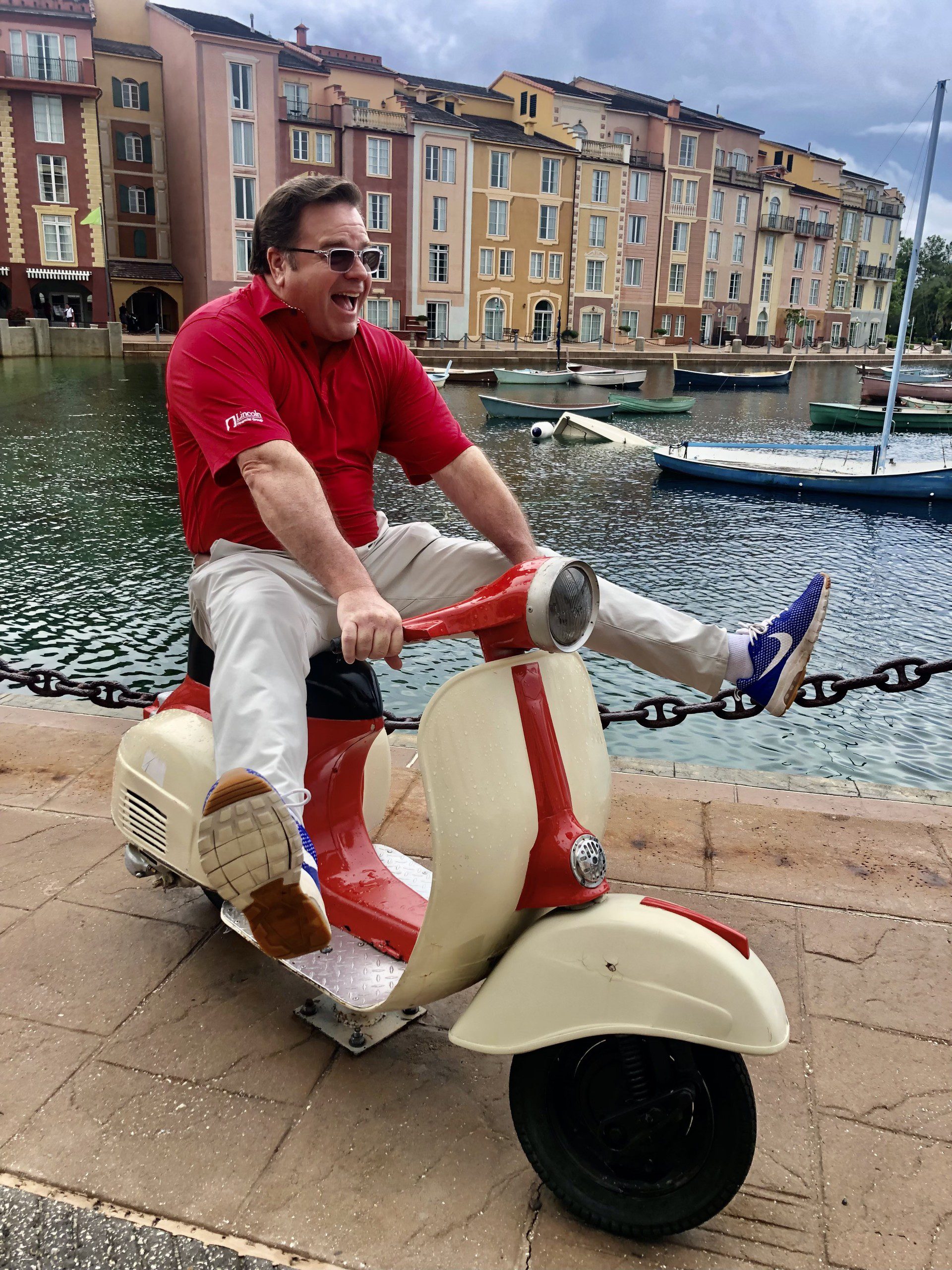 a man sitting on a moped in a goofy way